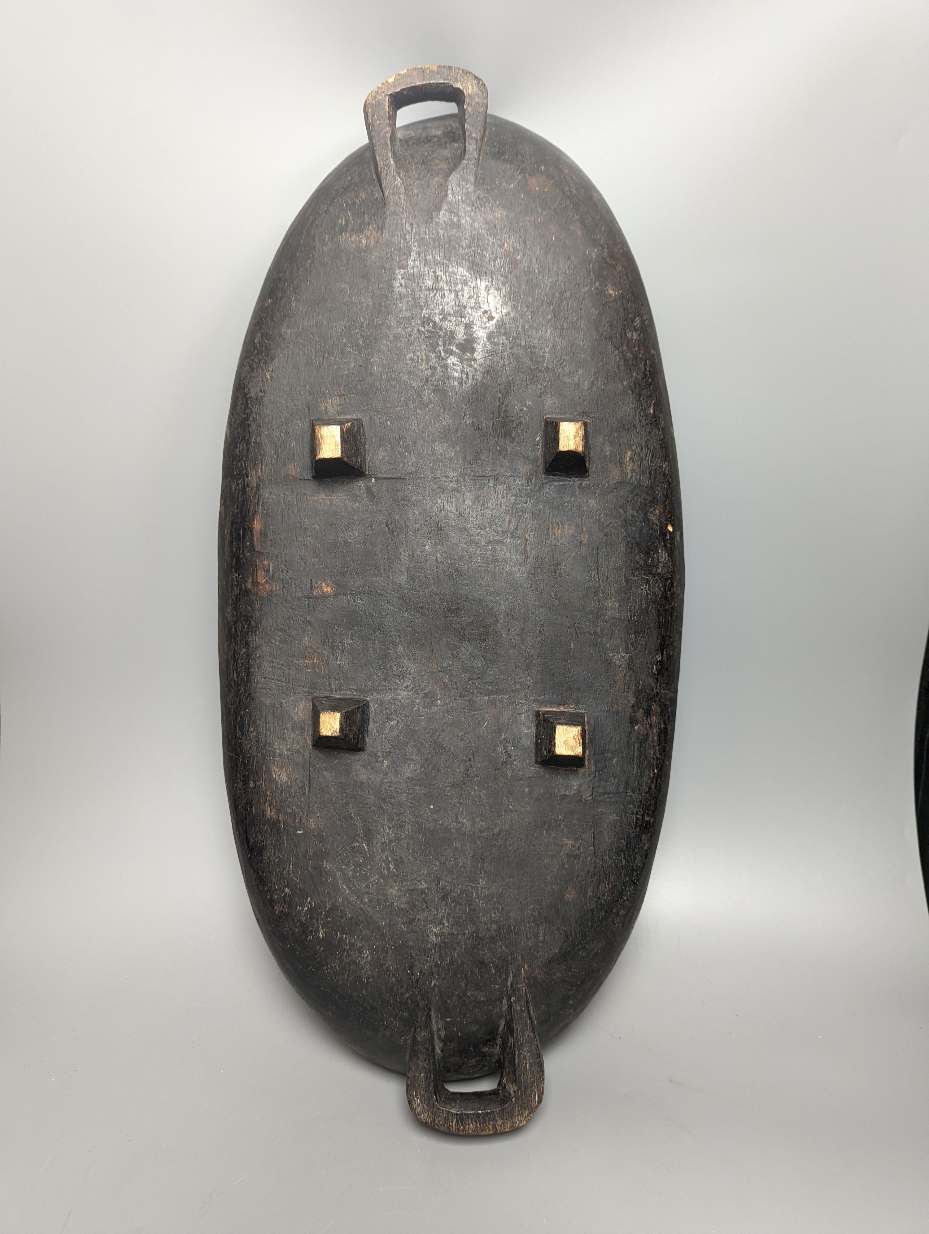 A large early 20th century West African hewn hardwood bowl raised on squared legs, length 63cm width 31cms